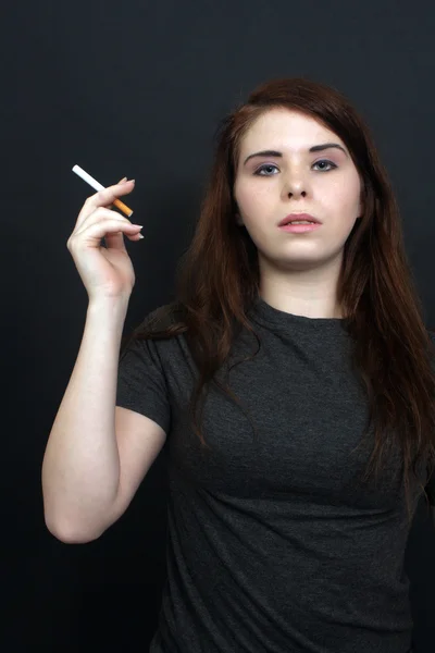 Hermosa morena sosteniendo un cigarrillo 1 Imagen de archivo