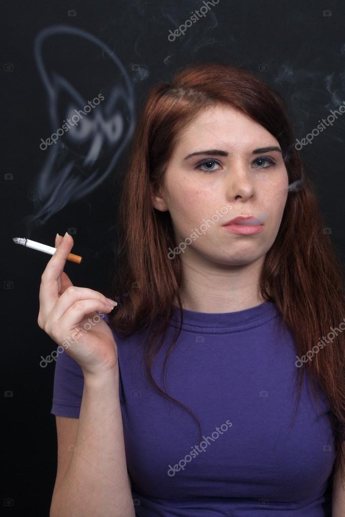 A Lovely Young Brunette Smokes A Cigarette And The Smoke Rises To Form A Scary Skull 17622899 Larastock