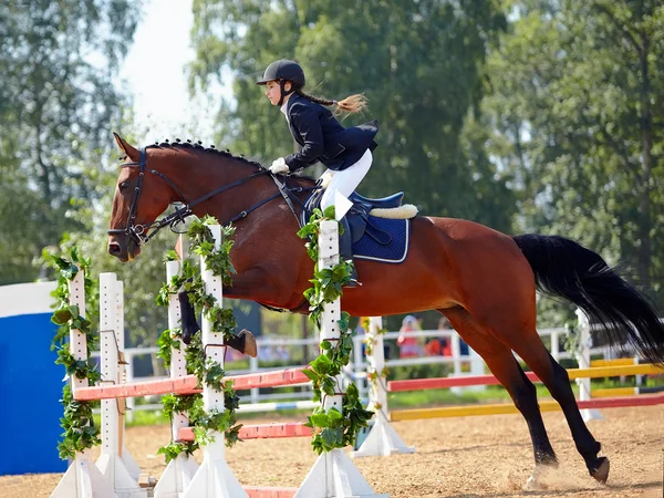 De Sportvrouw op een rood paard. — Stockfoto