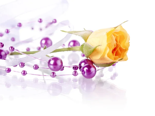 Yellow rose and violet beads. — Stock Photo, Image