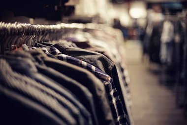 Mağazadaki askılarda satılık giysiler