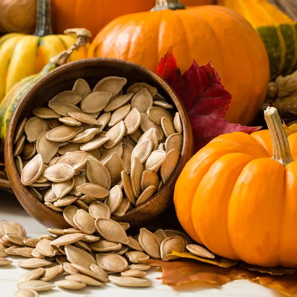 Toasted pumpkin seeds spilling from a yellow bowl — Stock Photo