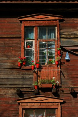 eski bir ahşap evin penceresinden çiçeklerle dekore edilmiştir.