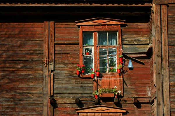 Çiçeklerle süslenmiş, ahşap bir evde pencere — Stok fotoğraf