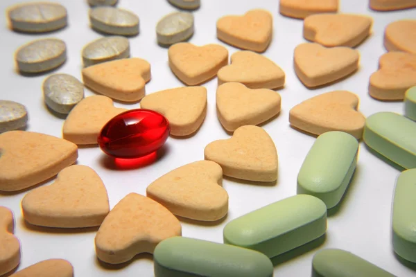 Czerwone kapsułki tabletki o różnych kolorach — Zdjęcie stockowe