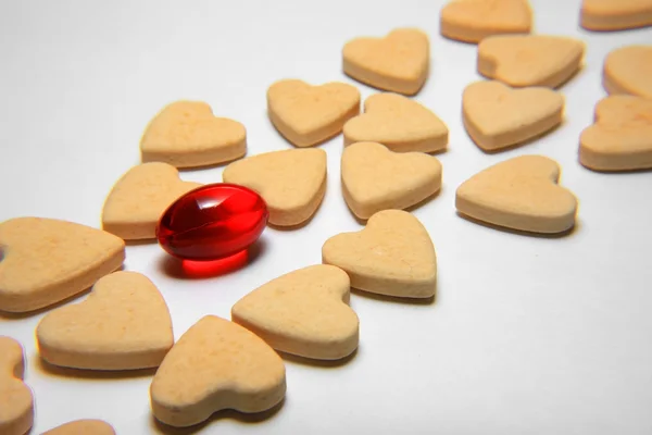 Červené kapsle tablet v podobě srdce — Stock fotografie