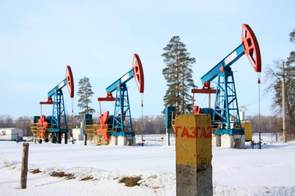 Column labeled "Gas" on the background of oil pump jacks — Stock Photo, Image