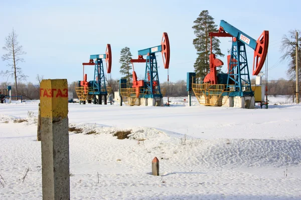 Column labeled "Gas" on the background of oil pump jacks — Stock Photo, Image