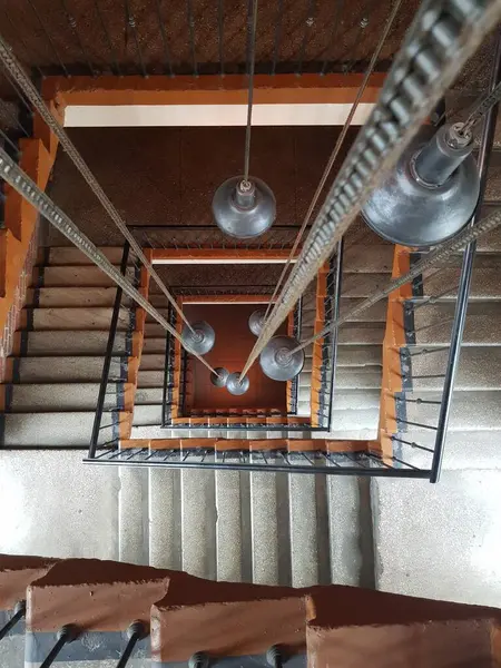 Merdiven boşluğunda yanan ampuller asılı.