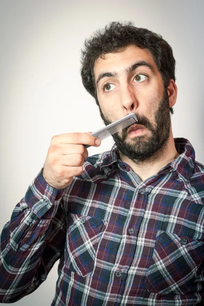 Young man want comb his beard and moustaches — Stock Photo, Image