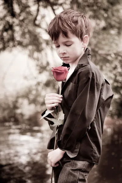 Αγόρι με τριαντάφυλλο στο χέρι του, ηλικίας φωτογραφίες, καλοκαίρι, πάρκο — Φωτογραφία Αρχείου