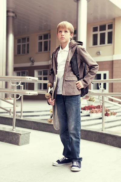 Teenager mit Schulranzen und Skateboard — Stockfoto