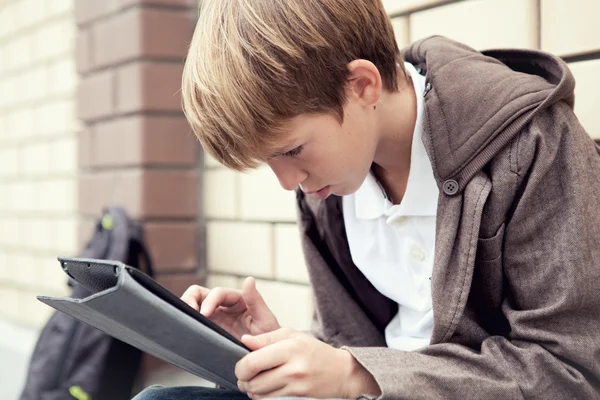 Skolan teen med elektroniska tablett sitter — Stockfoto