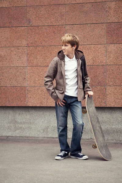 Adolescente da escola com saco escolar e skate — Fotografia de Stock