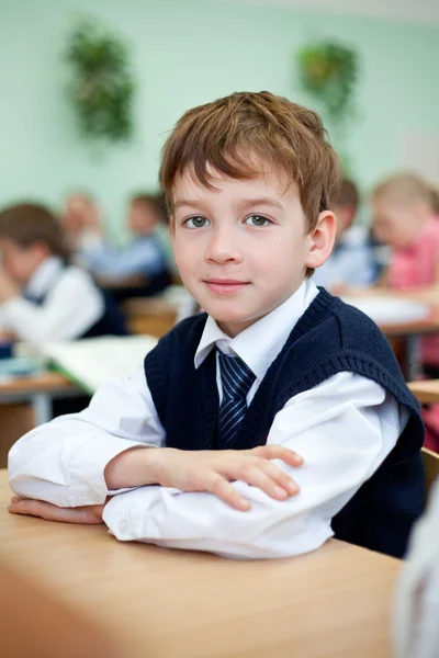 Pilný student sedí u stolu, učebny — Stock fotografie