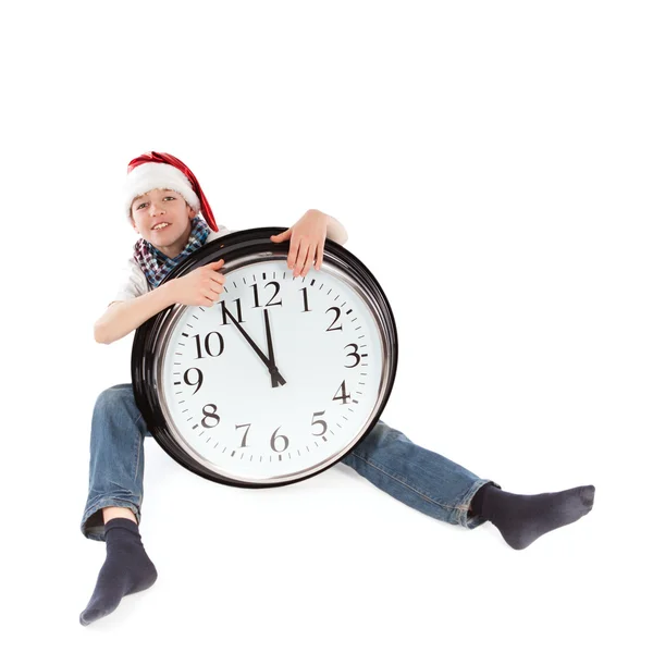 Teenager in cap of Santa Claus and large clock, isolation — Stock Photo, Image