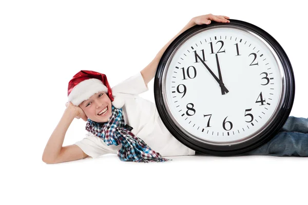 Teenager in cap of Santa Claus and large clock — Stock Photo, Image