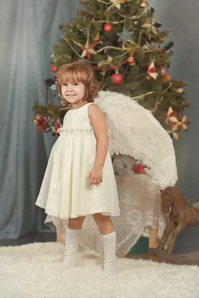 翼を持つエレガントな女の子がクリスマス ツリーについて — ストック写真