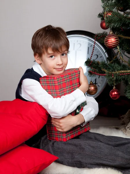 Happy child hugs Christmas gift — Stock Photo, Image
