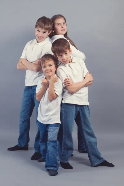 Skupina dětí v džínách na šedé vzdělání a zkušeností — Stock fotografie