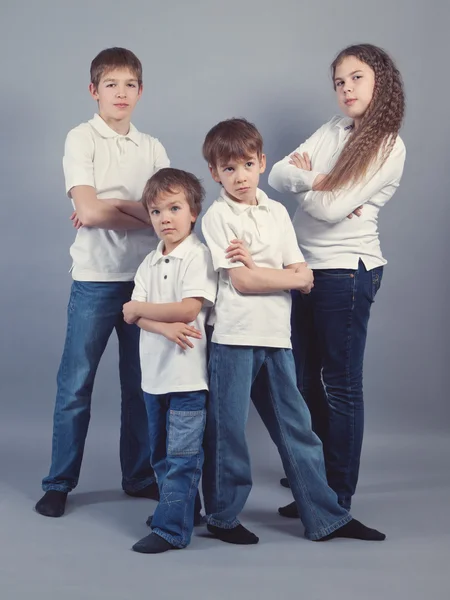 Група дітей в джинсах на сірому фоні — стокове фото