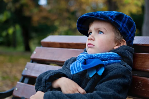Porträt eines Jungen auf Bank im Park — Stockfoto