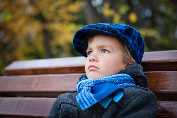 Retrato de menino no banco no parque — Fotografia de Stock