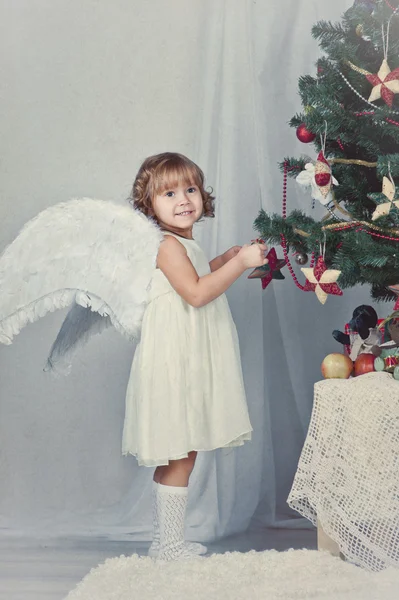 Csinos lány szárnyakkal öltözik, karácsonyfa — Stock Fotó