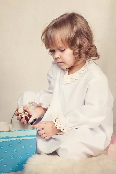 Девушка смотрит рождественские подарки — стоковое фото