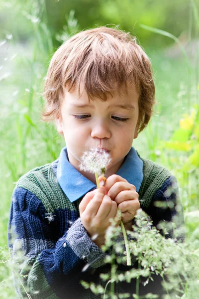 Porträt eines Jungen, der im Park auf Gras sitzt — Stockfoto