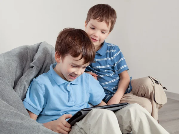 Два брата играют на планшете — стоковое фото