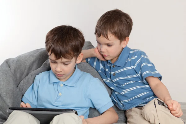 Два брата играют на планшете — стоковое фото