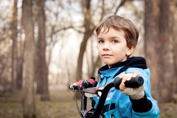 Portrait of serious boy with bicycle in park — Stock Photo, Image