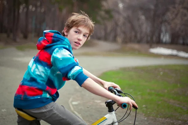 Porträtt av allvarlig pojke med cykel i park — Stockfoto