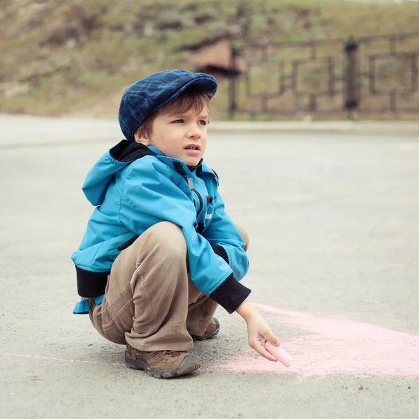 Мальчик рисует на дороге — стоковое фото