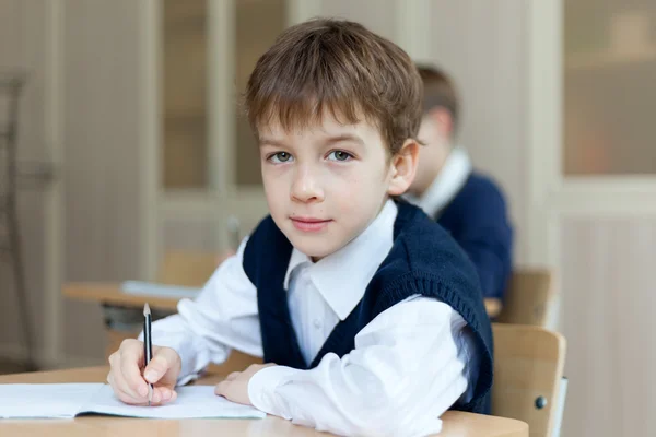 Estudante diligente sentado na mesa, sala de aula — Fotografia de Stock