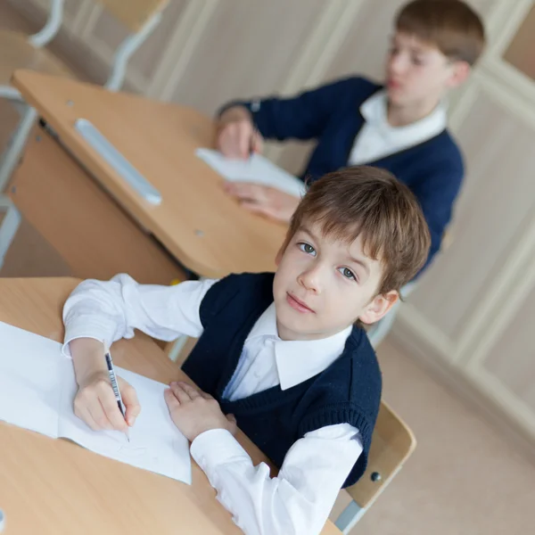 Flitig student sitter vid skrivbord, klassrummet — Stockfoto