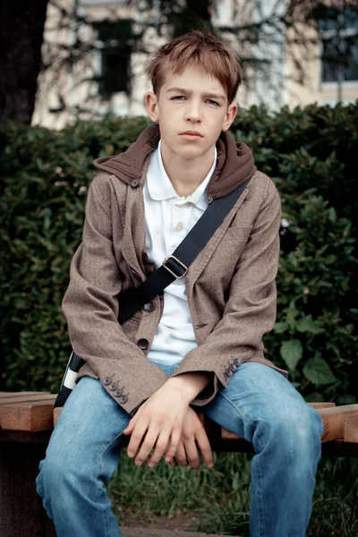 Ledsen tonåring sitter på bänken i park — Stockfoto