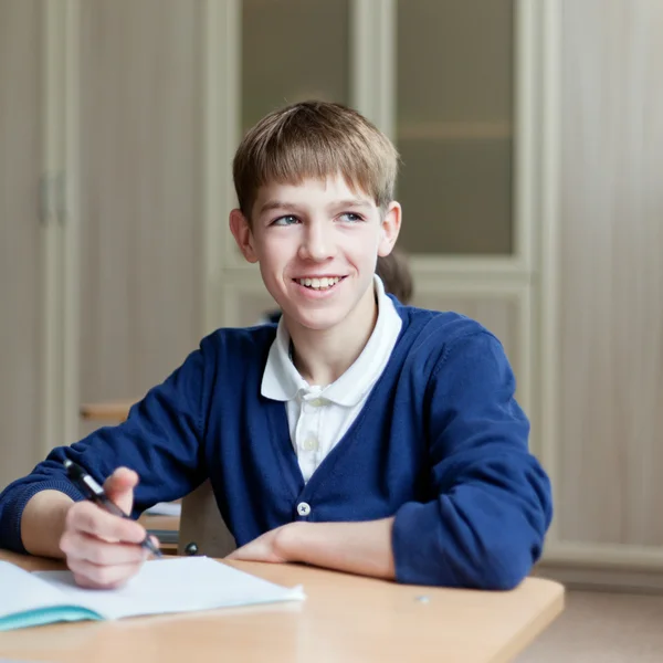 Sumienny student siedząc przy biurku, klasie — Zdjęcie stockowe