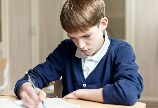 Pilný student sedí u stolu, učebny — Stock fotografie