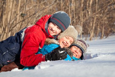rüzgârla oluşan kar yığını içinde oynayan winterwear mutlu çocuk