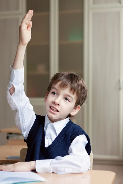 Fleißiger Schüler sitzt am Schreibtisch, Klassenzimmer — Stockfoto