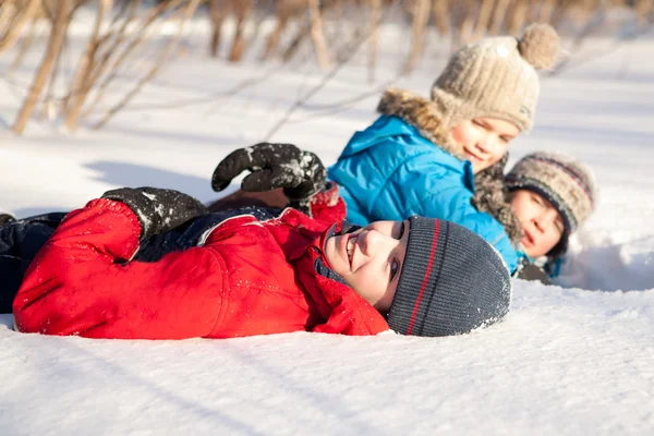 Kinderen in winterwear spelen in sneeuwjacht — Stockfoto