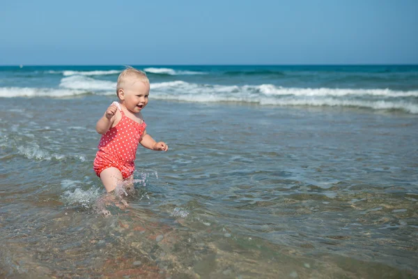 Adorable girl walking along beach — Stock Photo, Image