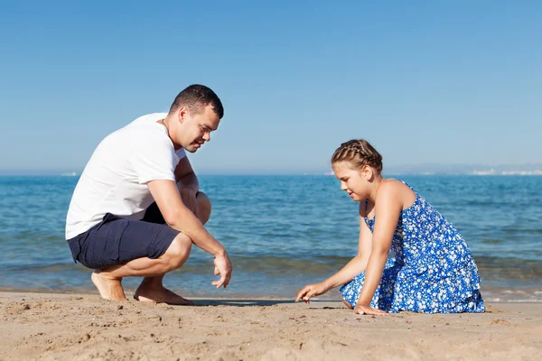 Glücklicher Vater und seine kleine Tochter am Strand — Stockfoto