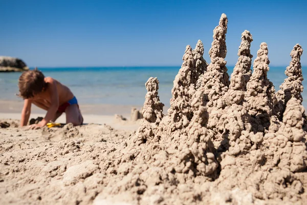 Menino fazendo castelo de areia na praia — Fotografia de Stock