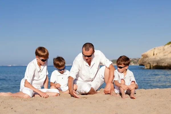 Padre e hijos caminando en la playa — Foto de Stock
