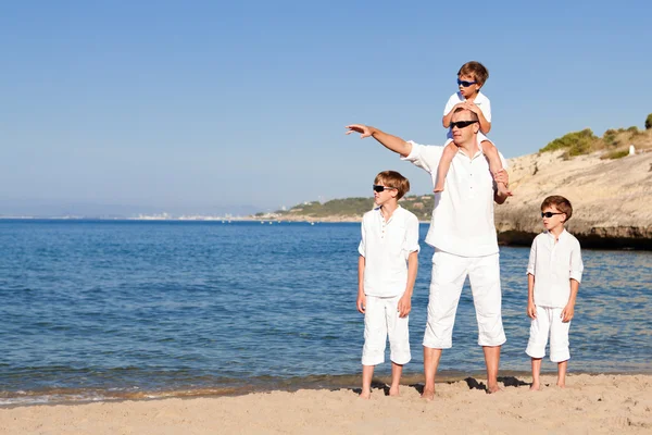 Отец и сыновья, идущие по пляжу — стоковое фото
