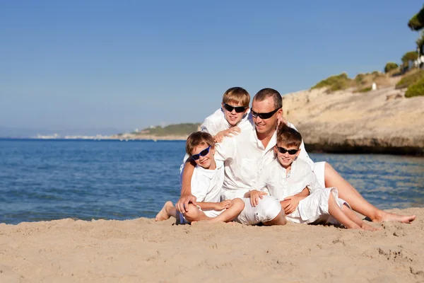 Padre e hijos caminando en la playa — Foto de Stock