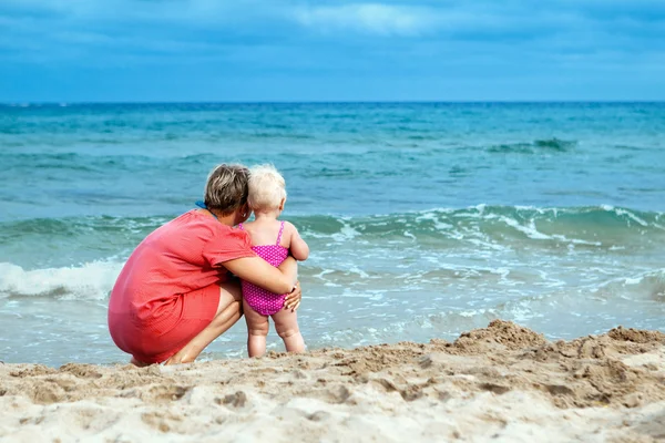Mãe feliz e sua filhinha na praia — Fotografia de Stock